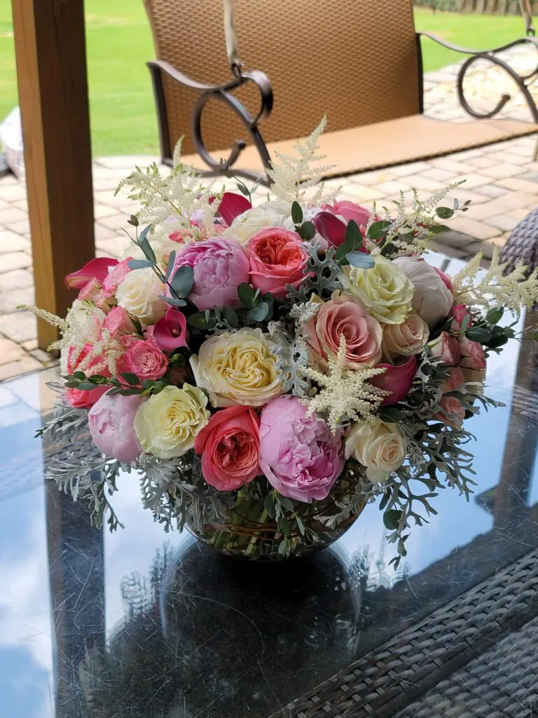 A vase filled with pink and white flowers is sitting on a table.