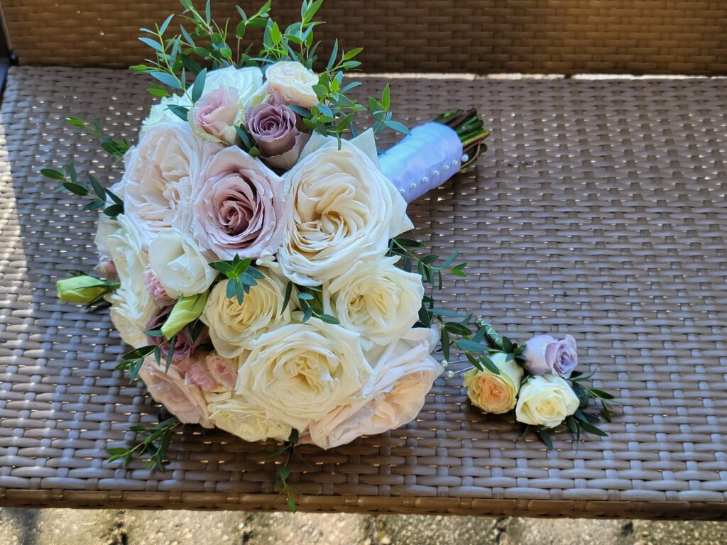 A bouquet of flowers is sitting on a wicker bench.