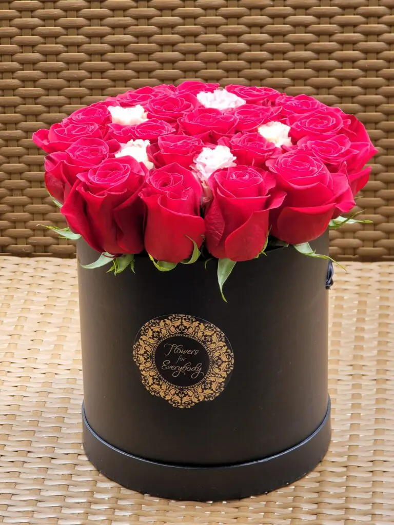 A black box filled with red roses and white hearts.