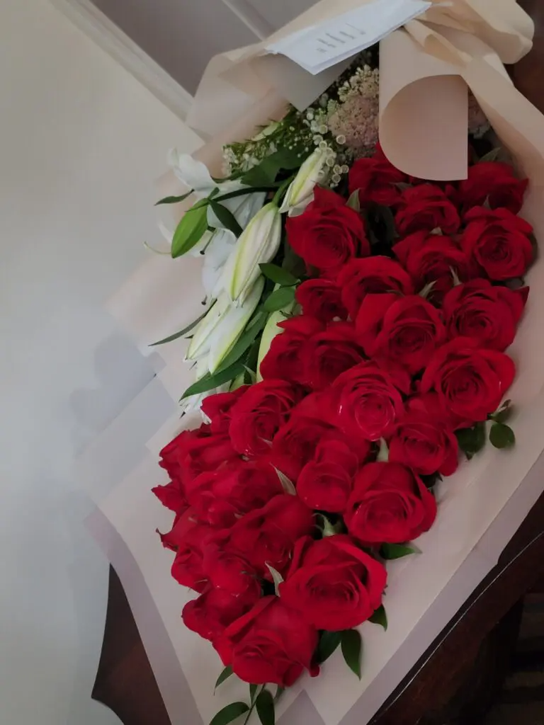 A bouquet of red roses and white lilies on a table