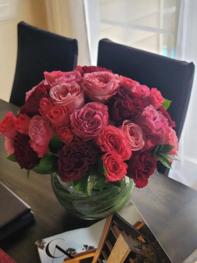 A vase filled with red roses sits on a table