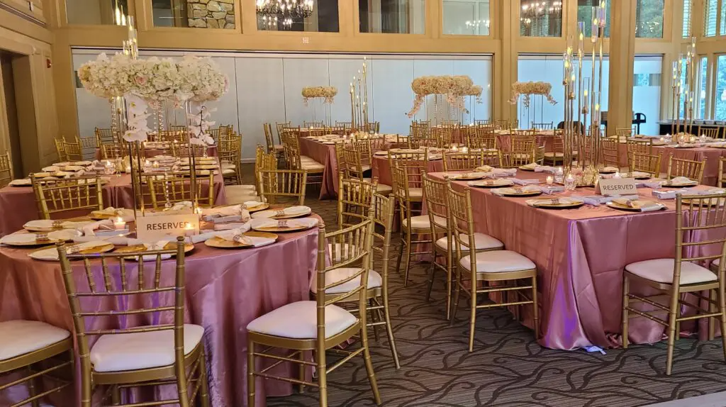 A large room with tables and chairs set up for a wedding reception.