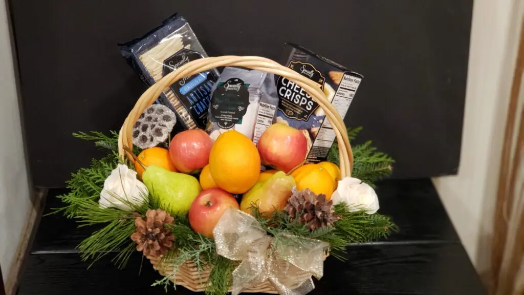 A basket filled with fruit and vegetables is sitting on a table.