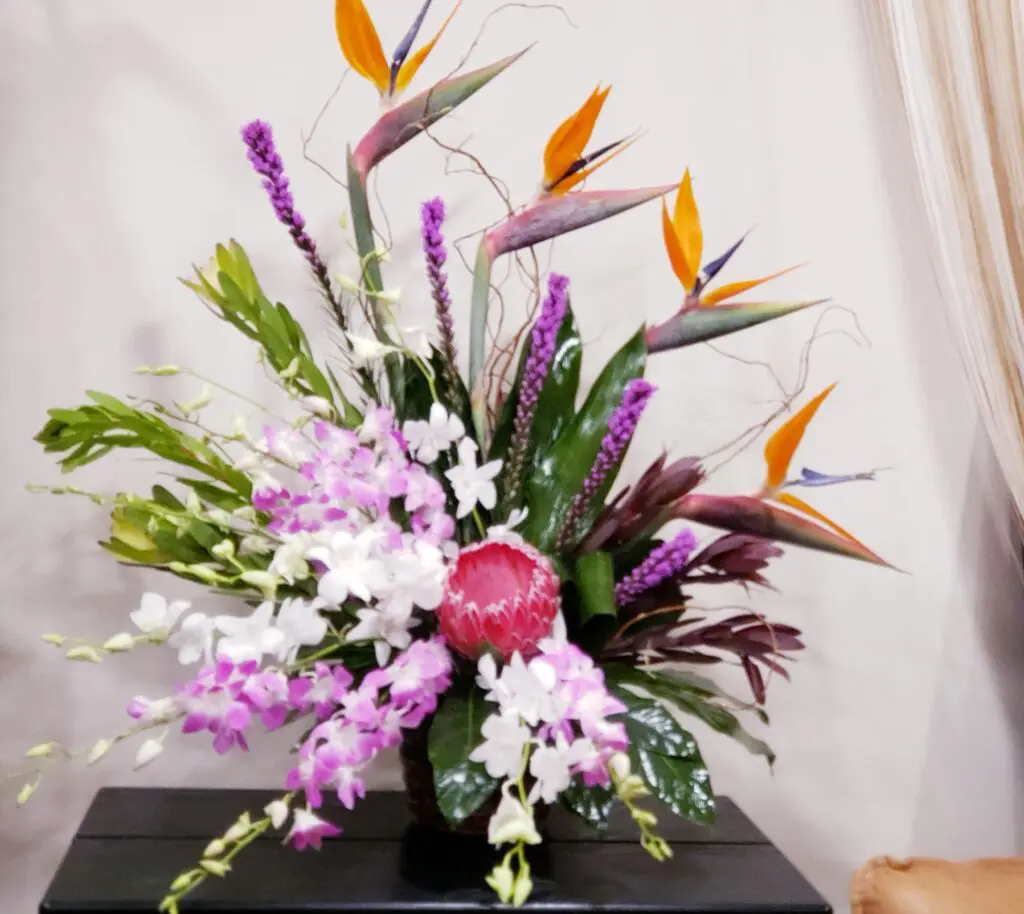 A vase filled with purple and white flowers sits on a table