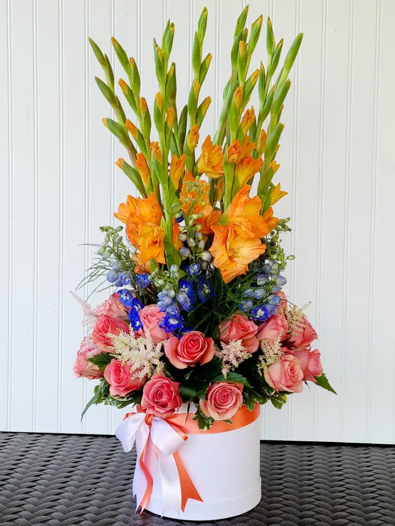 A white box filled with flowers is sitting on a table.