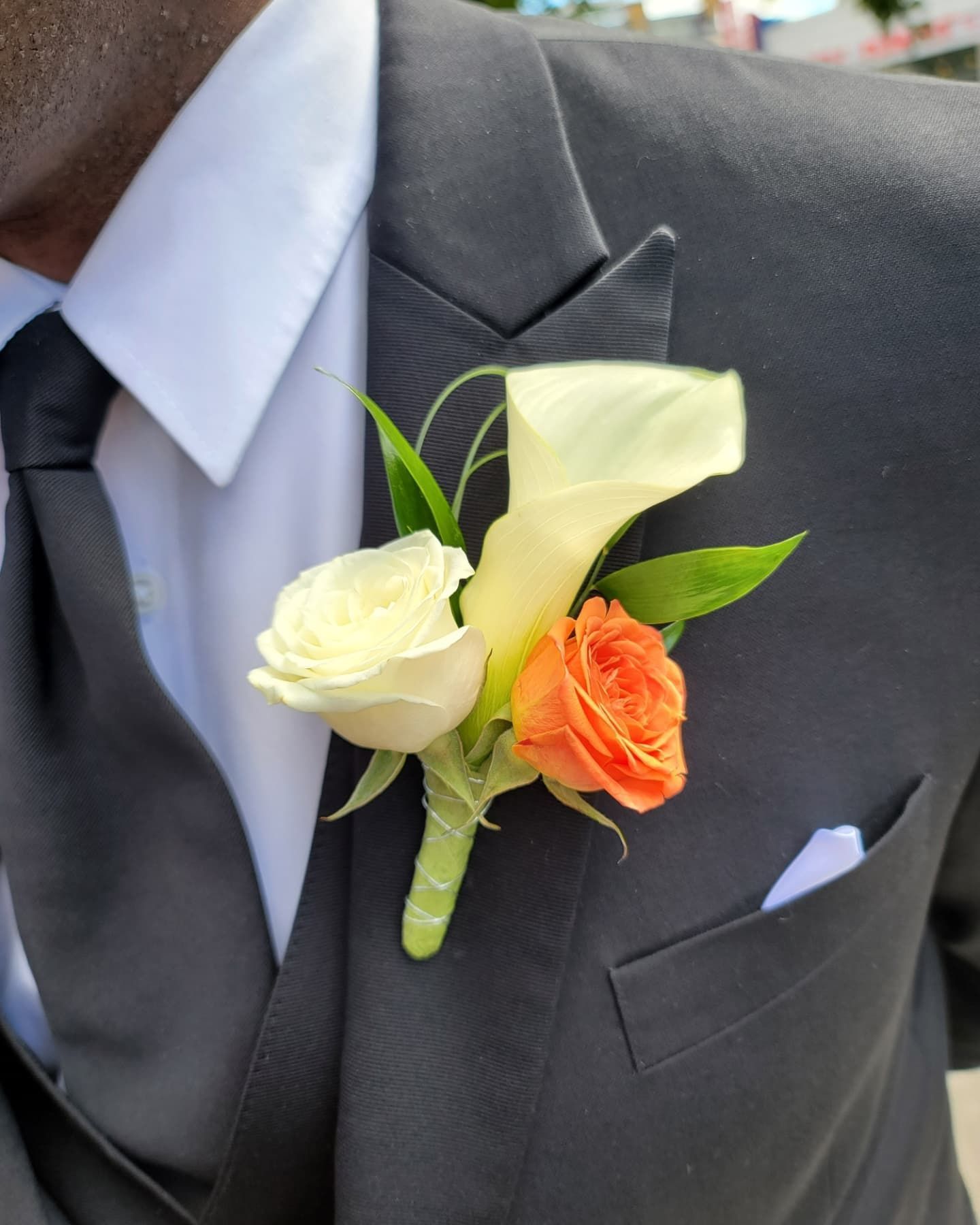 A man in a suit has a flower in his pocket