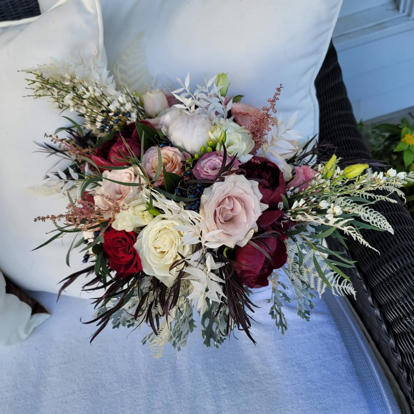 A bouquet of flowers is sitting on a pillow on a couch