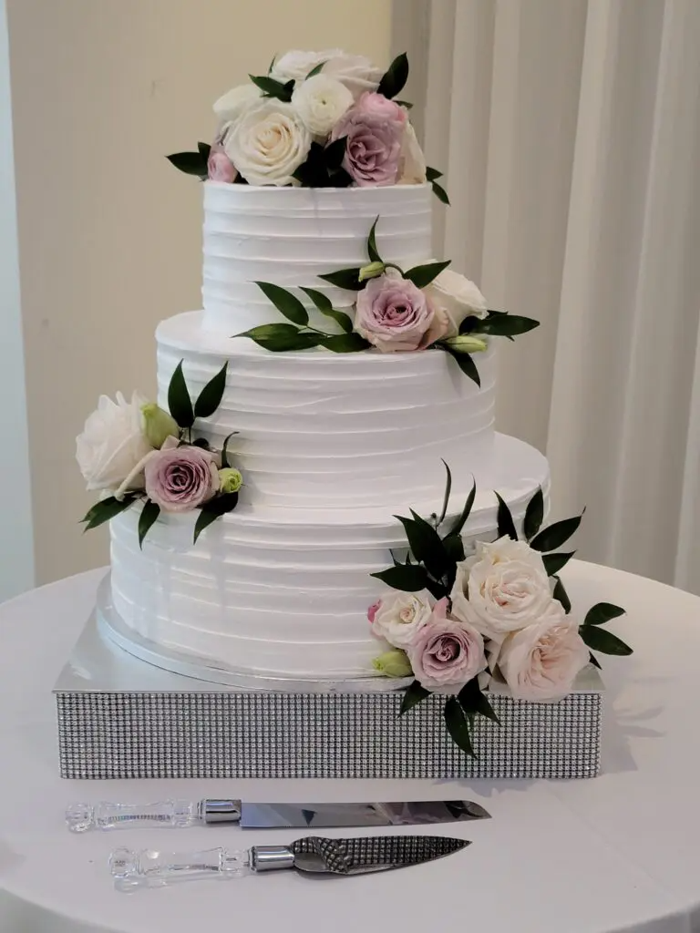 A wedding cake with flowers on top of it is sitting on a table.