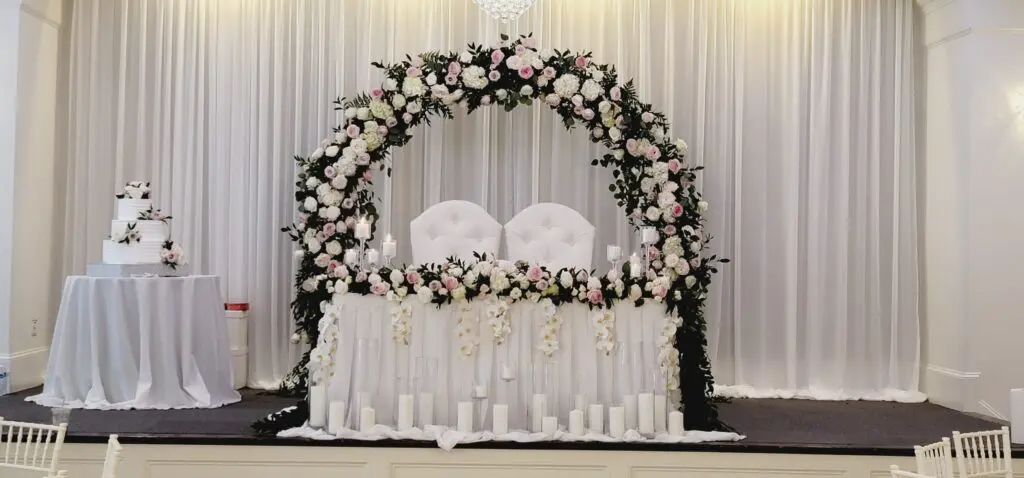 A wedding reception with a table and chairs decorated with flowers and candles.