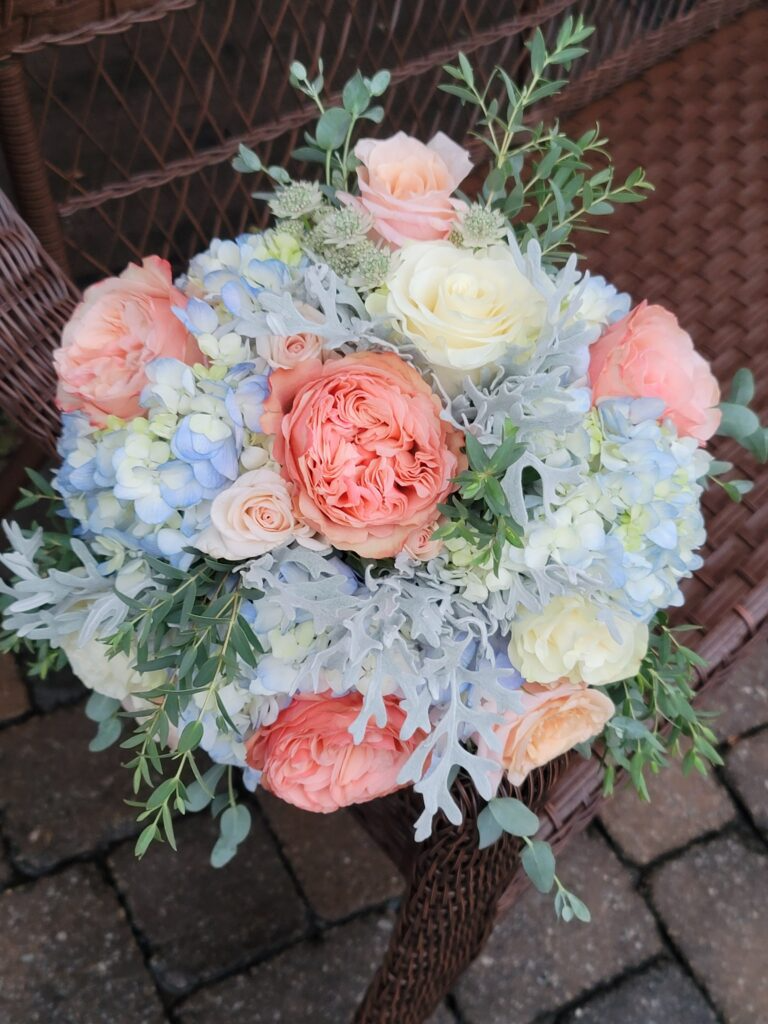 A bouquet of flowers is sitting on a wicker chair.