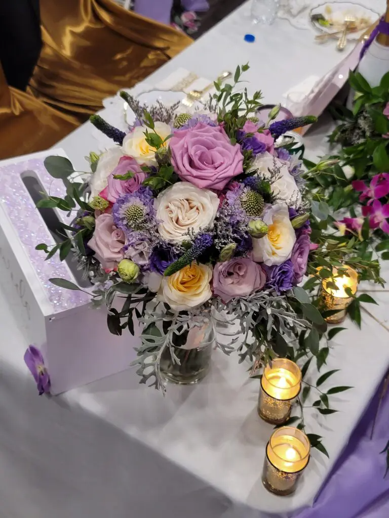 A table with a bouquet of flowers and candles on it.