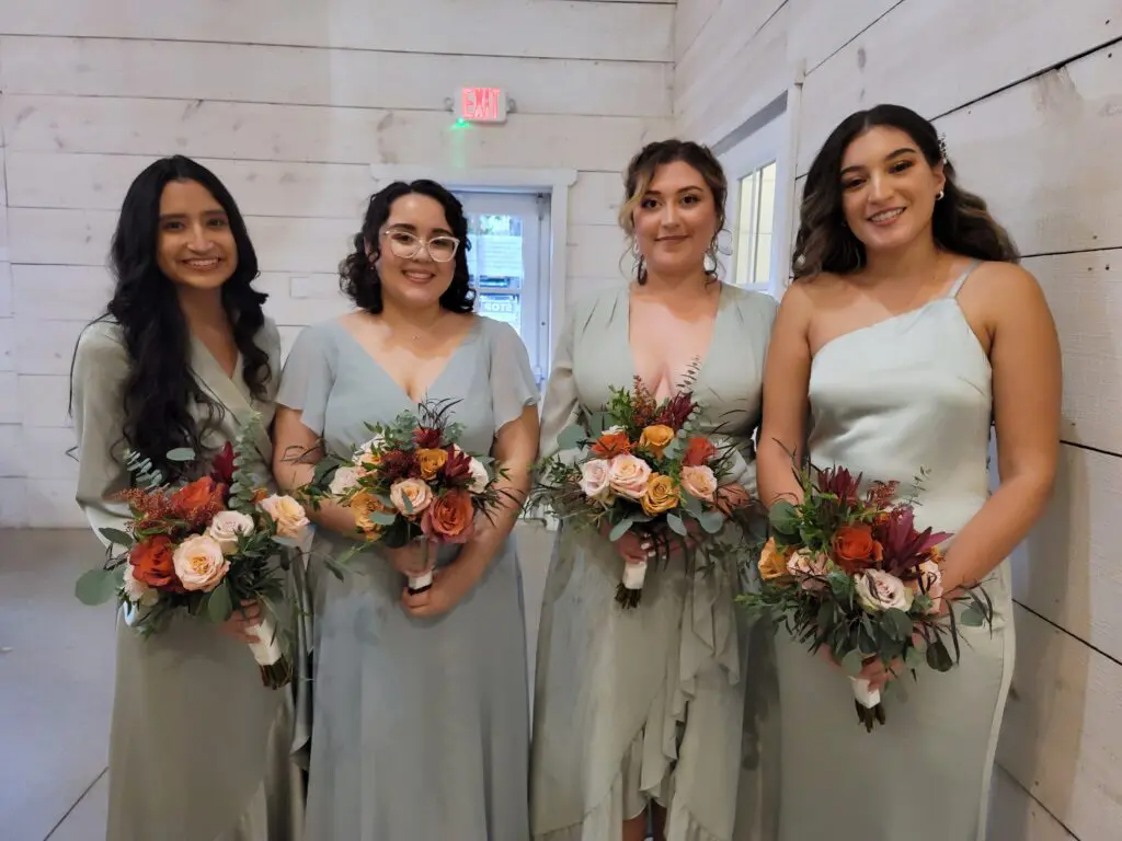 A group of bridesmaids standing next to each other holding bouquets of flowers.