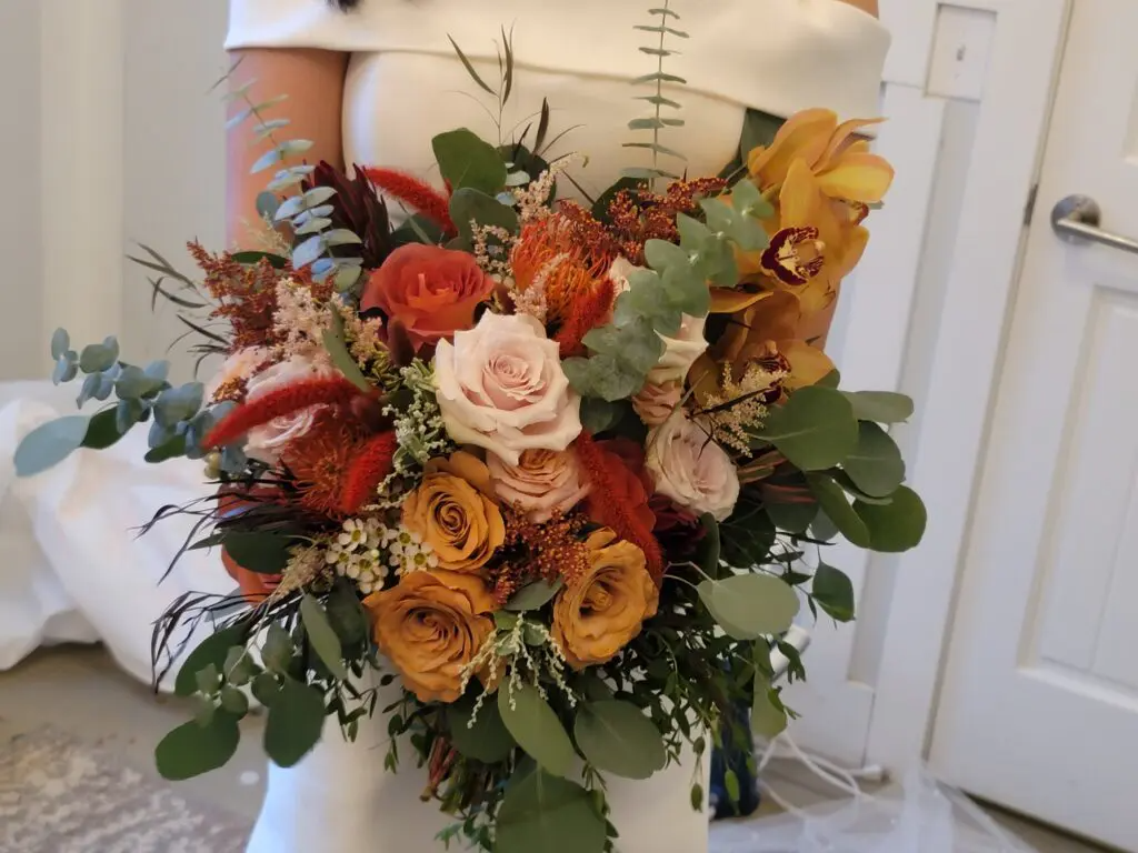 A woman in a white dress is holding a bouquet of flowers.
