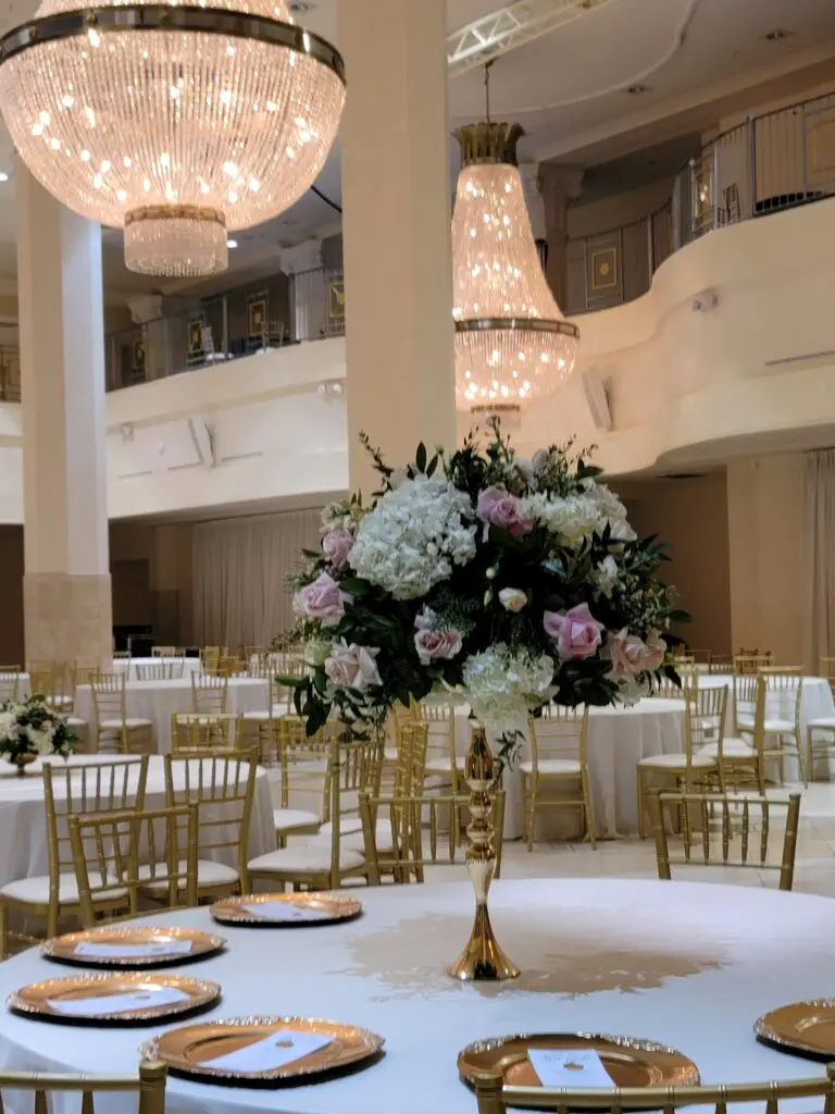 A large room with tables and chairs and a vase of flowers