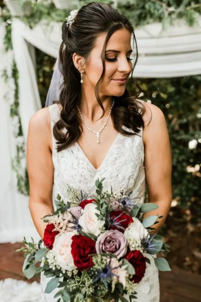 A bride in a wedding dress is holding a bouquet of flowers.