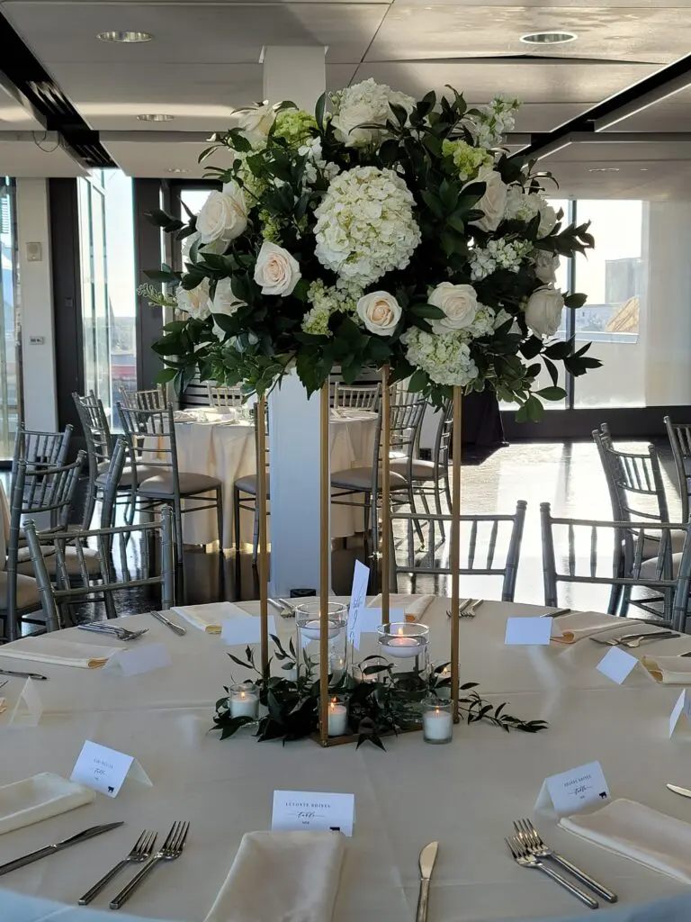 A table with a vase of flowers and candles on it