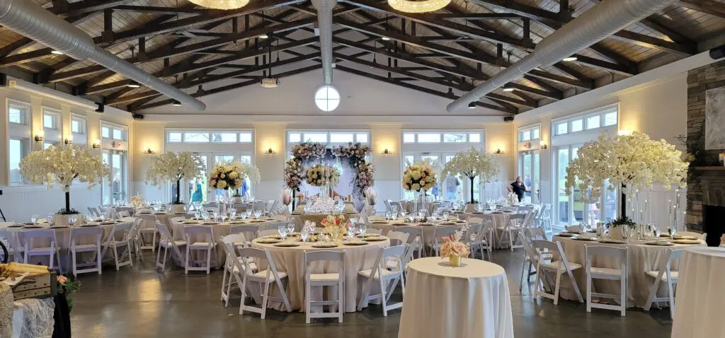 A large room with tables and chairs set up for a wedding reception.
