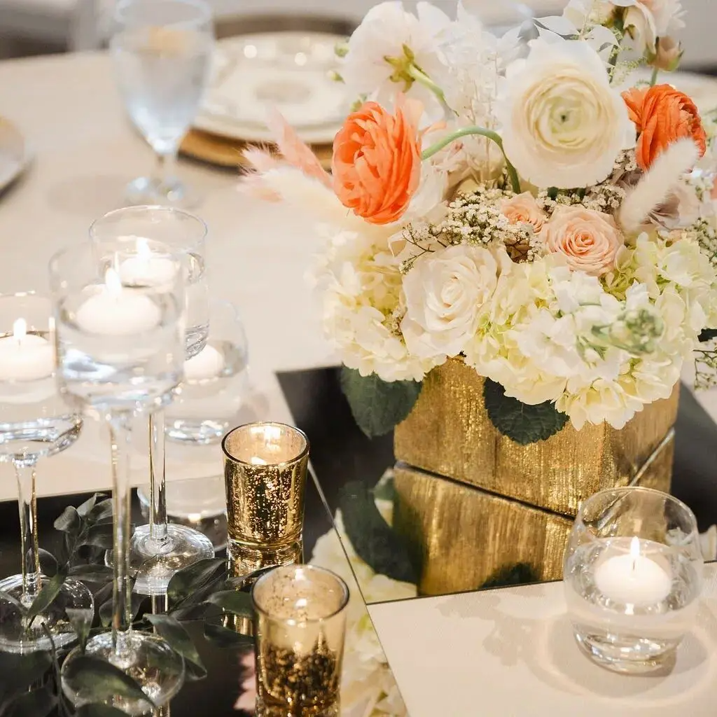A table with a vase of flowers and candles on it