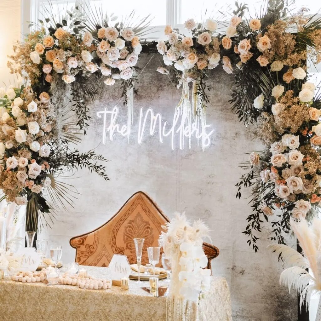 A wedding reception with flowers and a neon sign that says `` the millers ''.