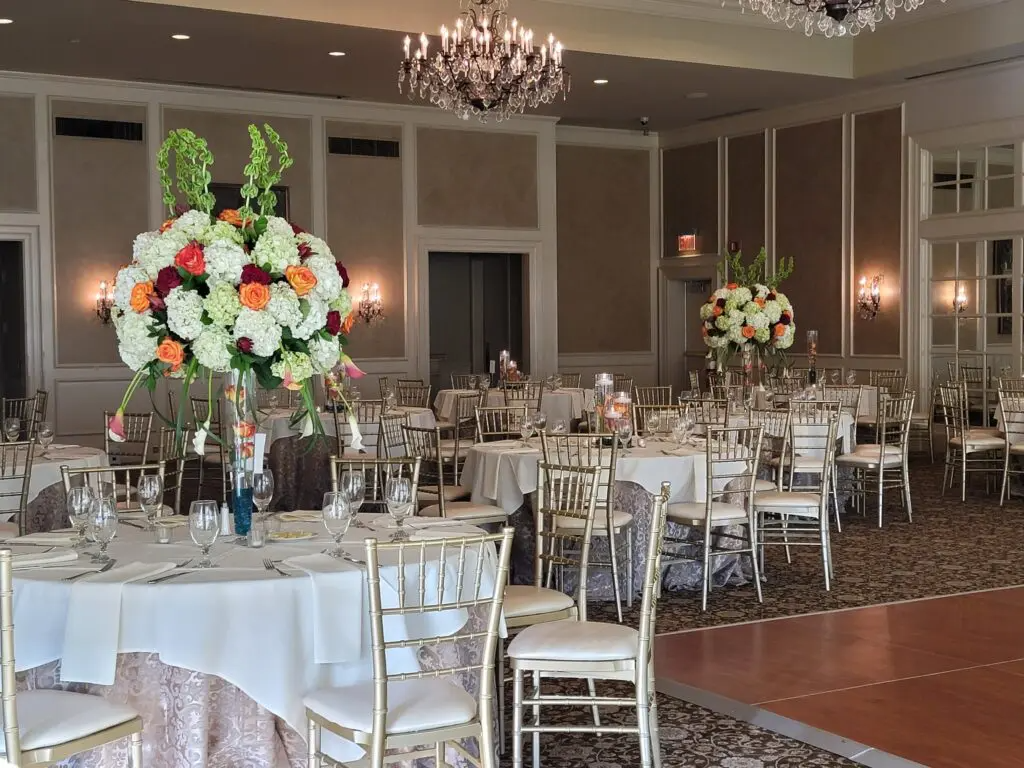 A large room with tables and chairs set up for a wedding reception.