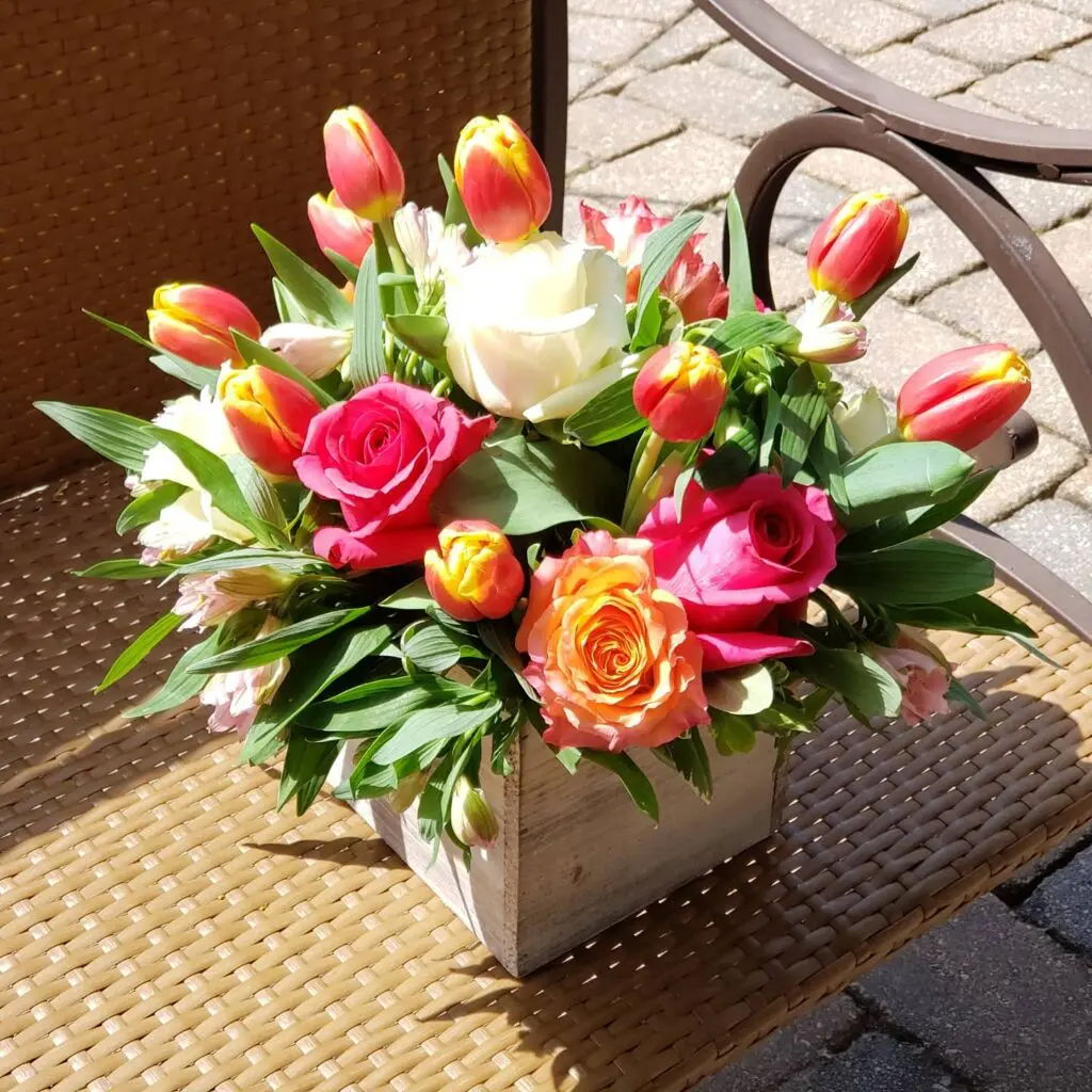A vase filled with flowers is sitting on a wicker chair