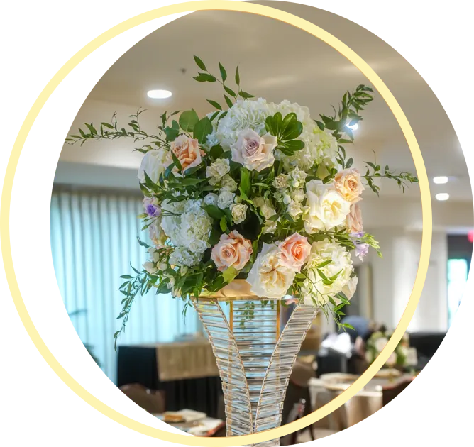 A tall vase filled with flowers in a room A tall vase filled with flowers in a room