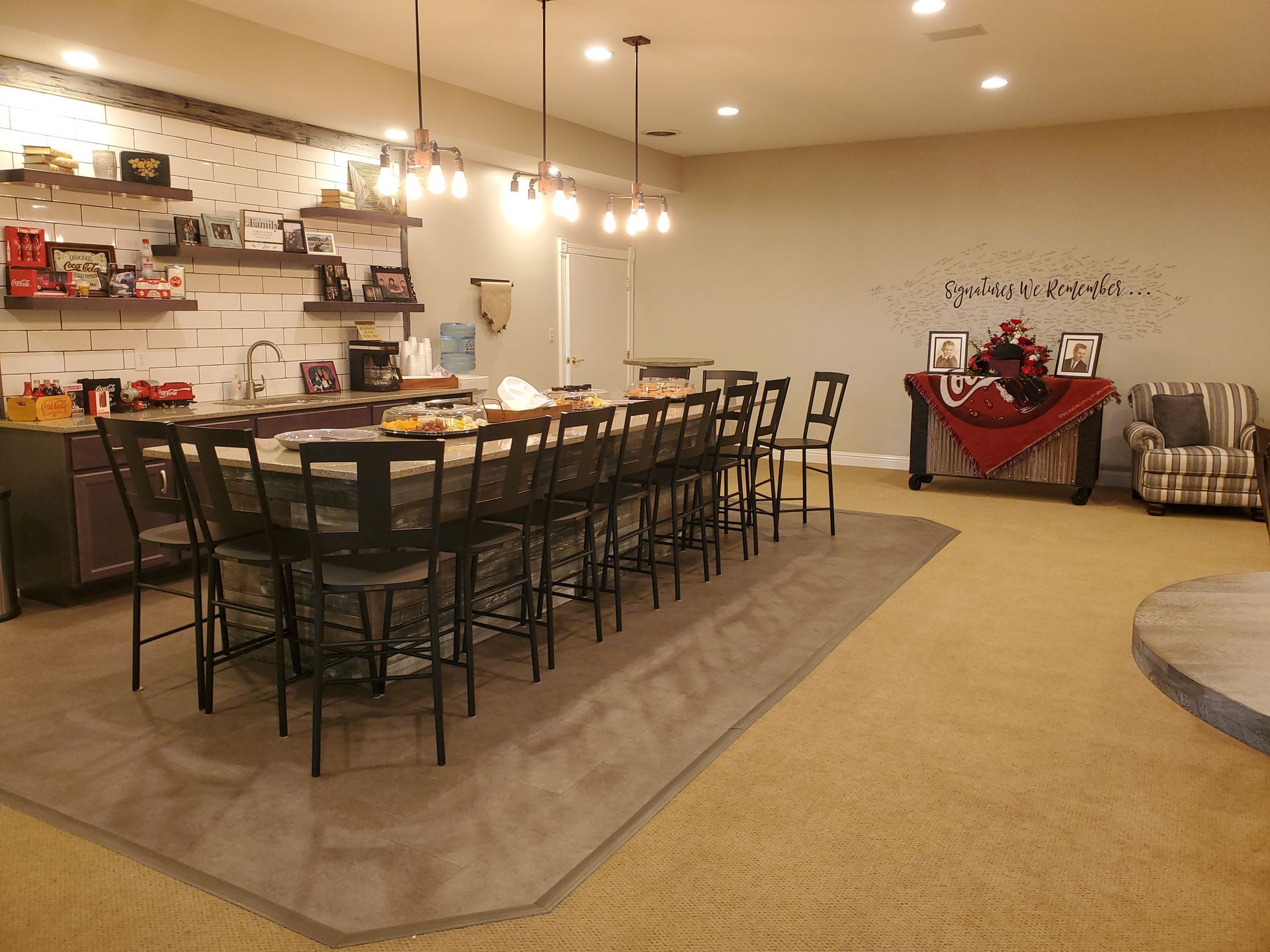 Modern showroom with a long dining table, shelves, and a seating area on a carpeted floor