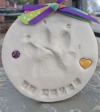 White circular clay paw print keepsake with 