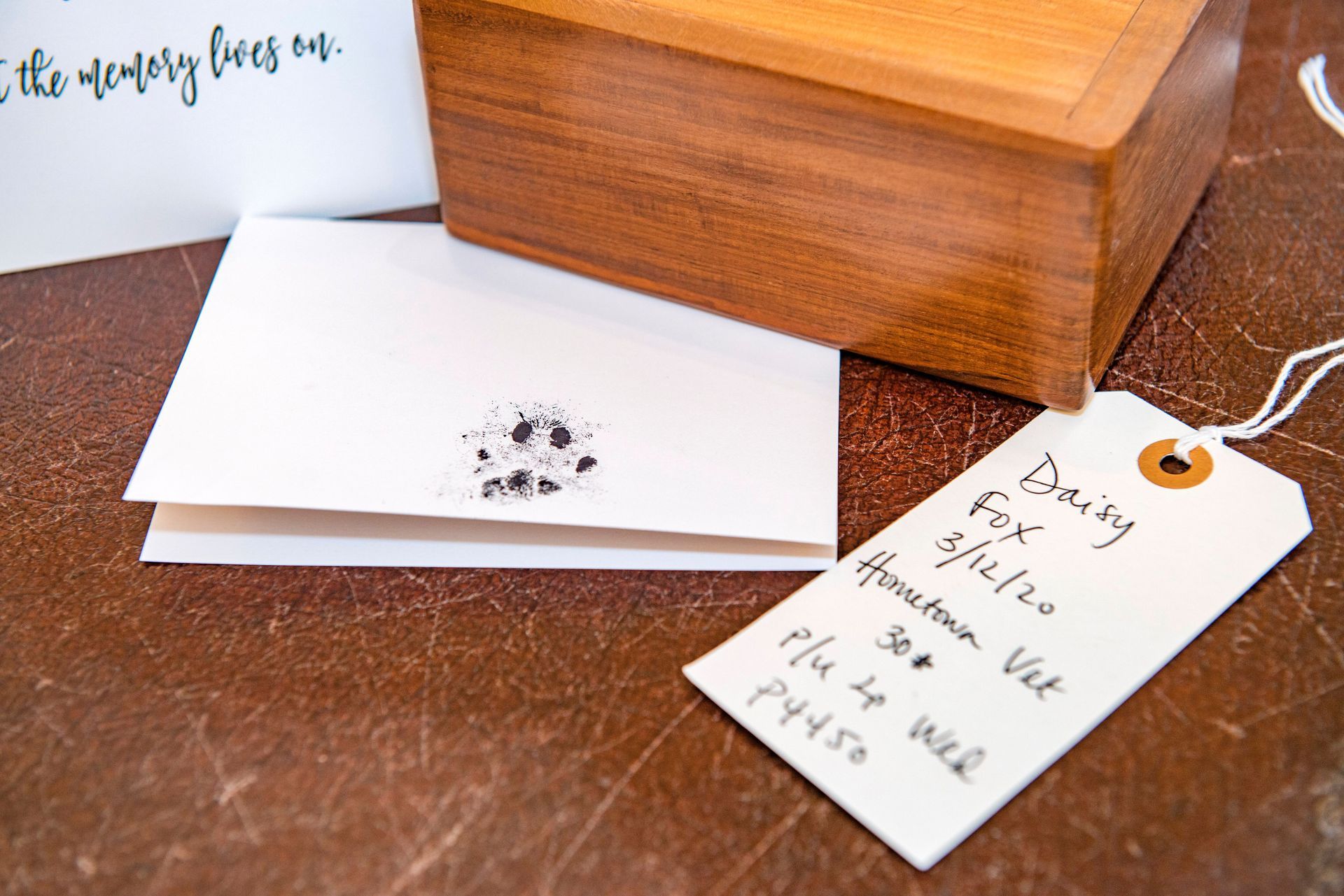 Wooden box, card, and tag on a brown surface. Tag reads 