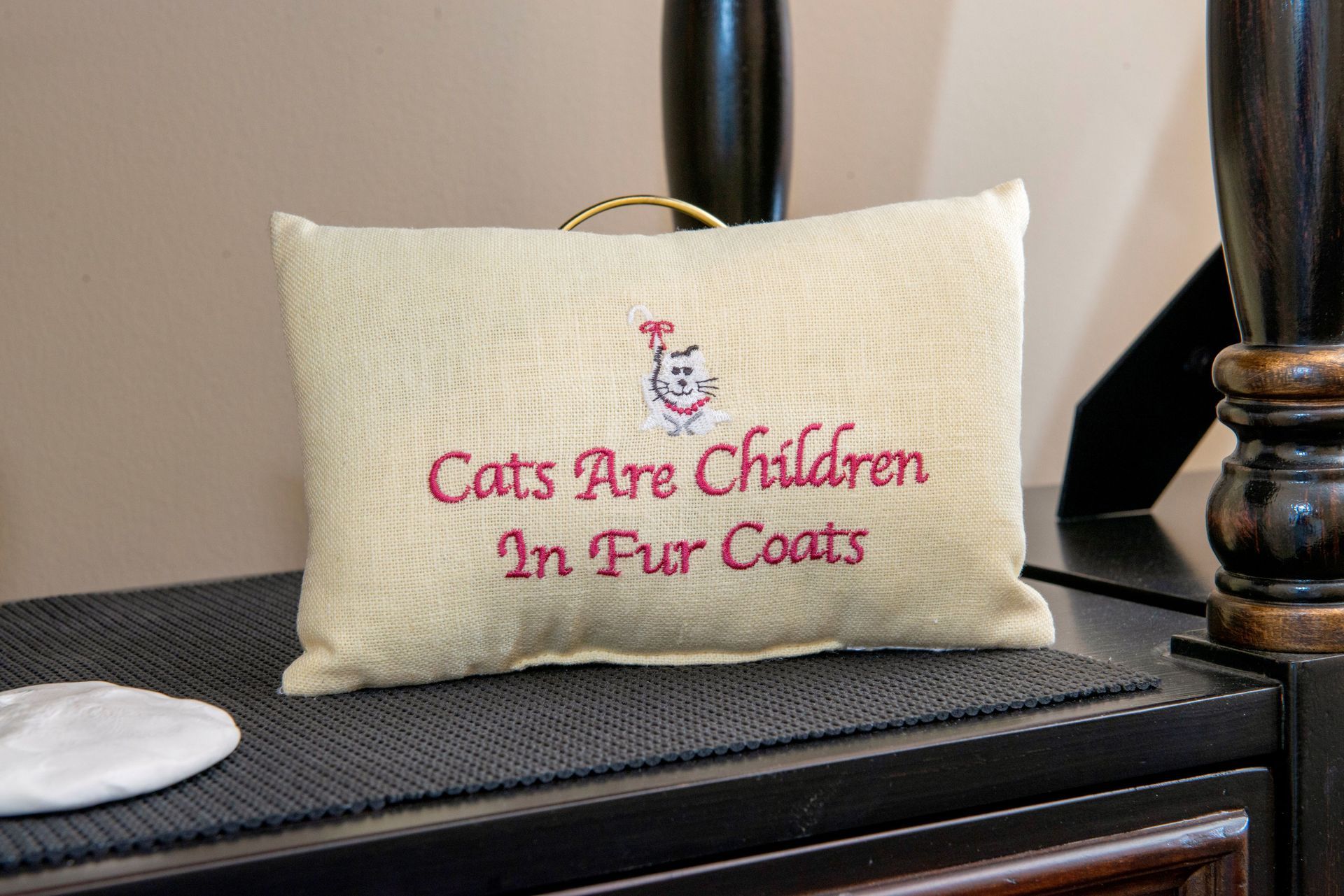 Beige pillow with embroidered text 