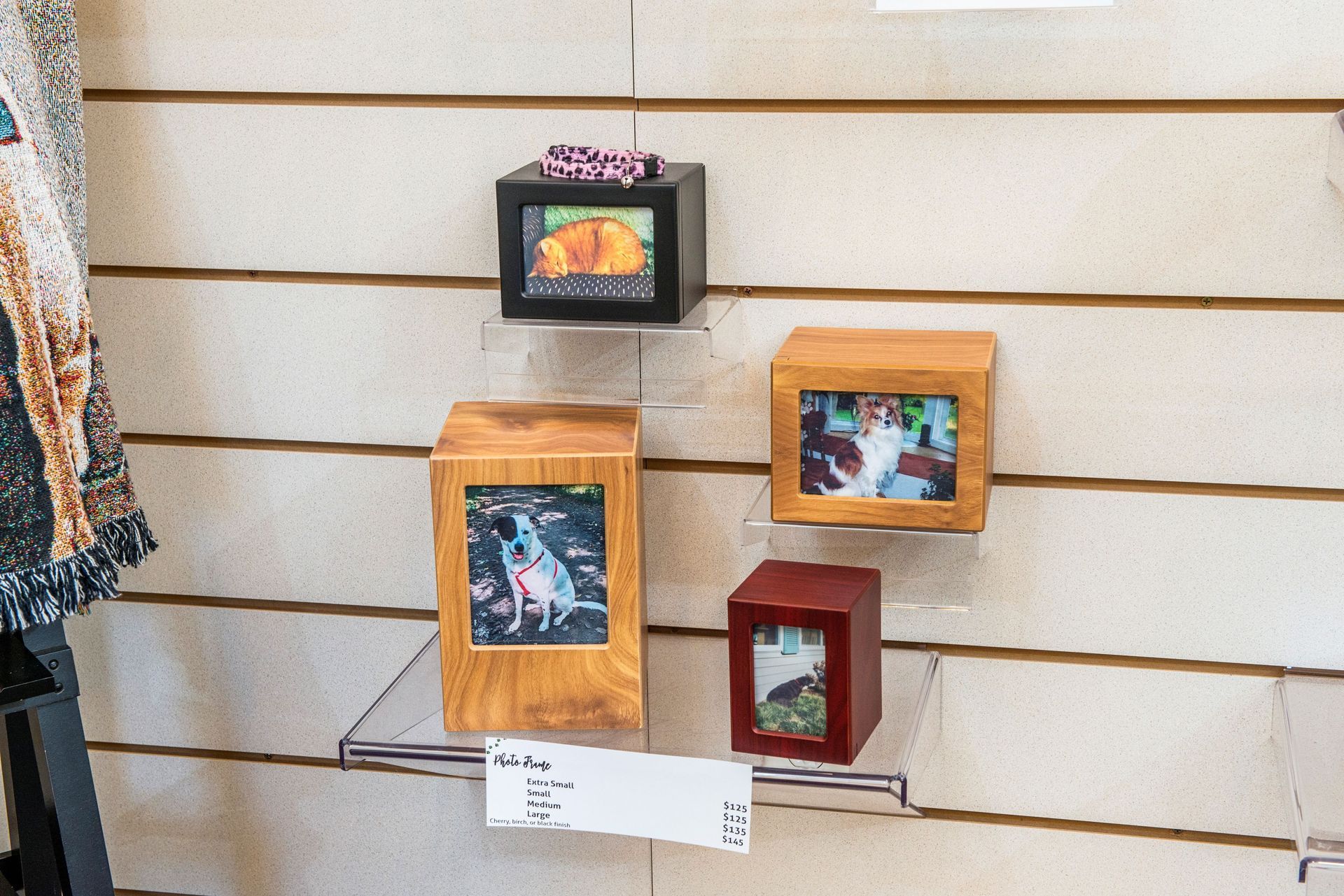 Four square wooden frames with photos on a shelf against a wood-paneled wall.