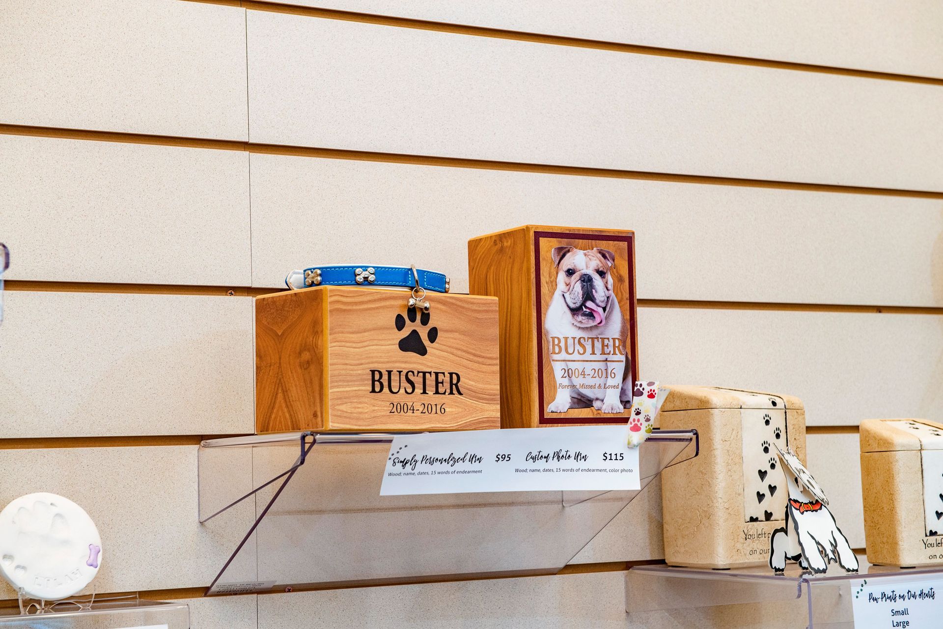 Wooden pet urns with a dog collar and paw print.