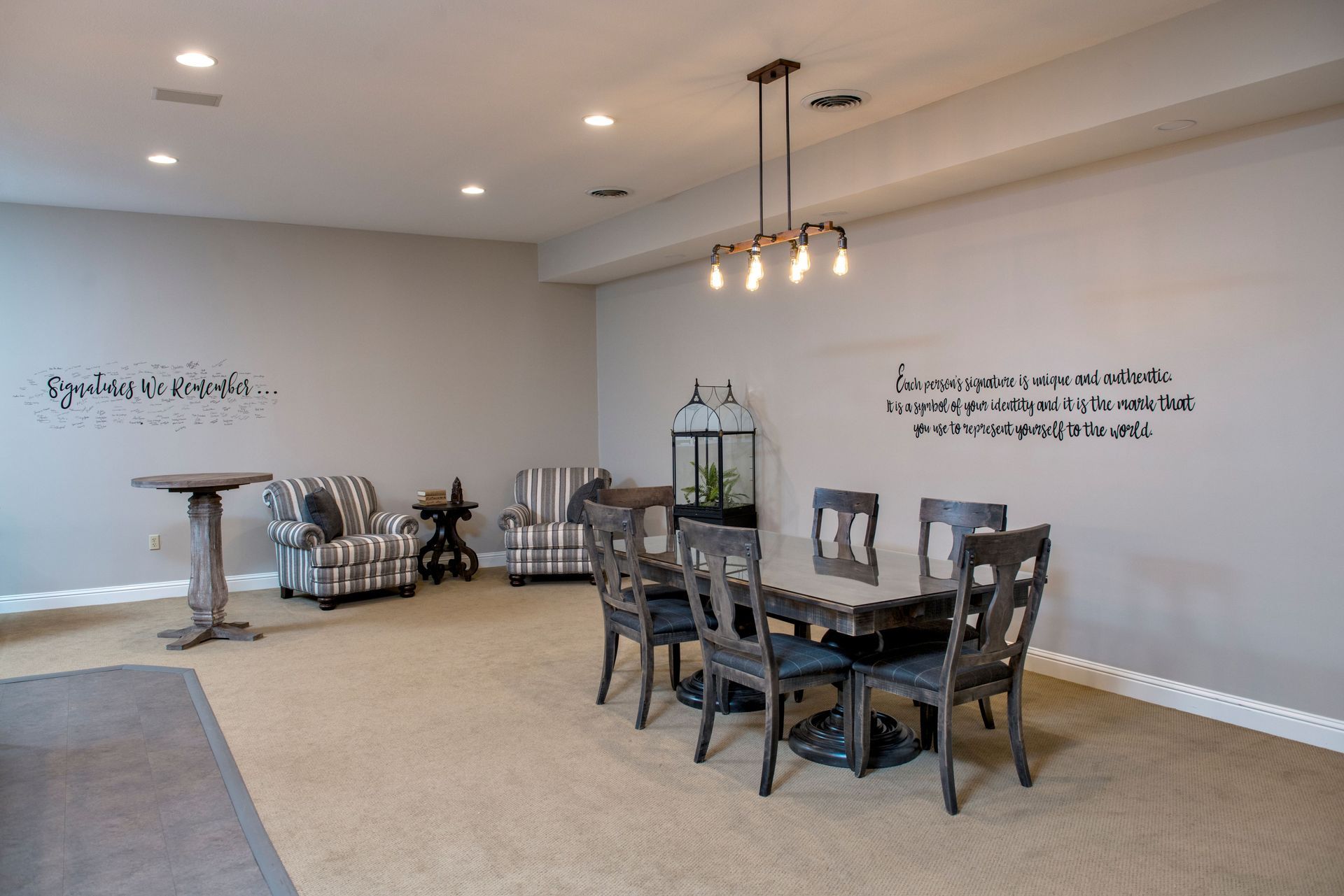 Dining room with table, chairs, bar table, armchairs, and decorative lighting and wall art.