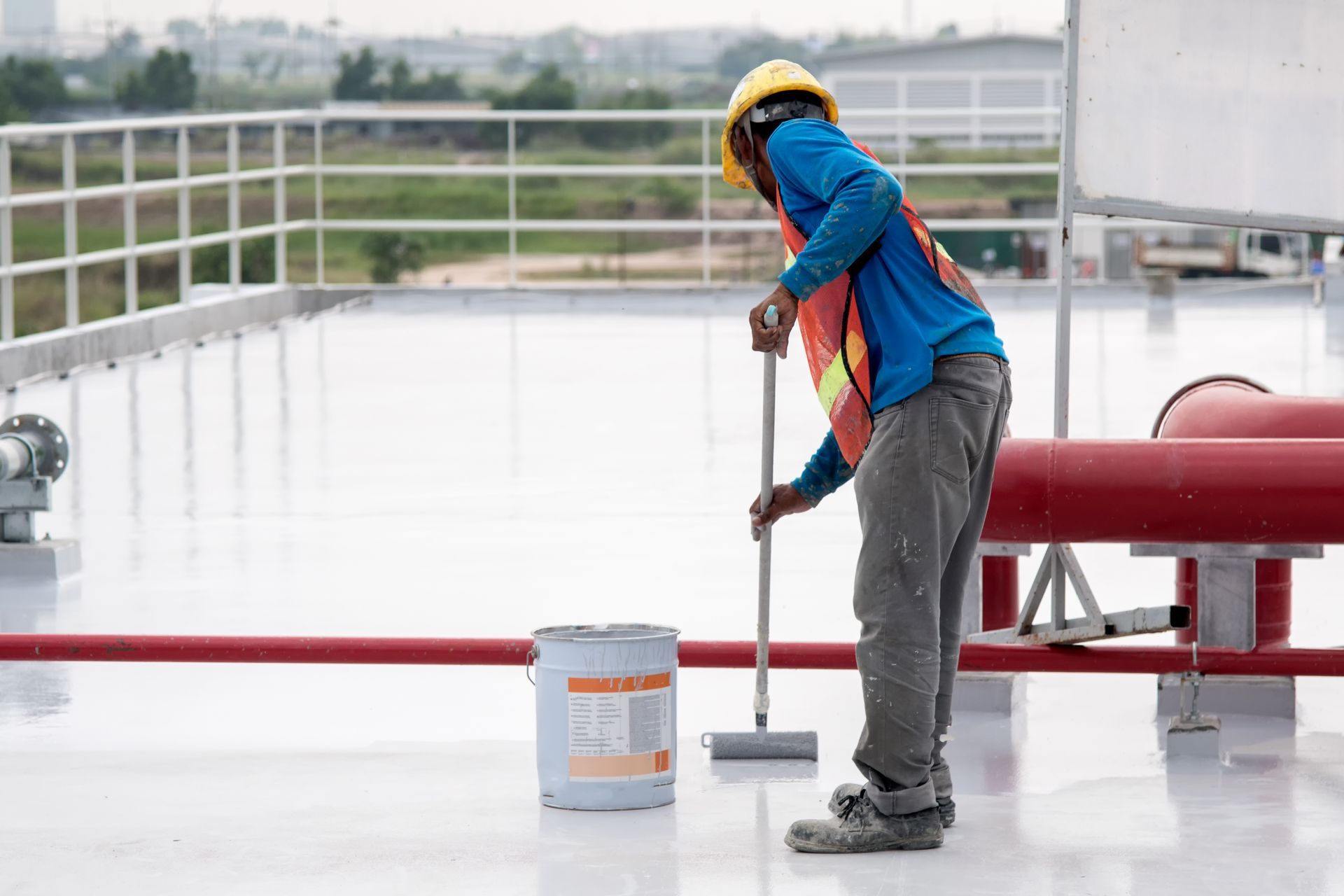 a man is painting a roof with a roller .