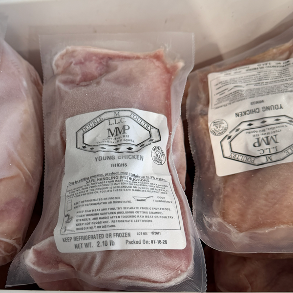 frozen chicken breasts in a clear package with a white label.