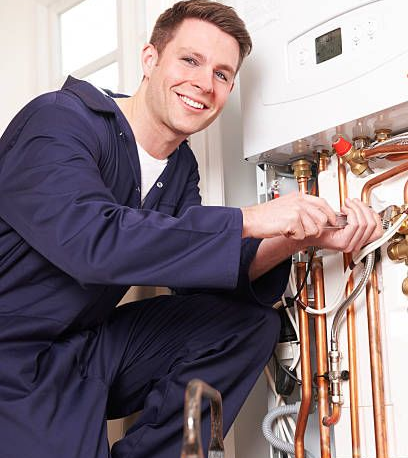 Smiling technician installing copper water heater pipes.