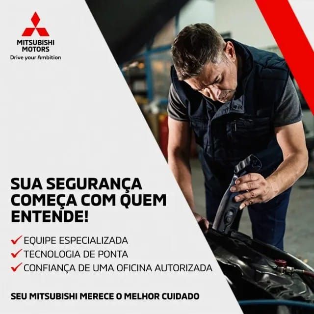 Dois mecânicos de macacão azul examinam o motor de um carro em uma garagem.