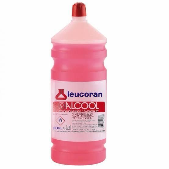Bottiglia rosa di alcol Leucoran con tappo rosso su sfondo bianco.