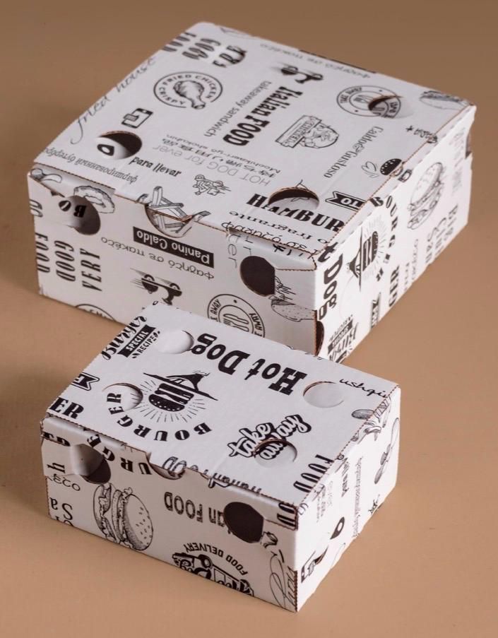 Due scatole regalo bianche impilate, con grafiche nere in stile doodle su una superficie beige.