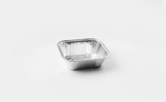 Piccola teglia da forno vuota in alluminio su sfondo bianco.