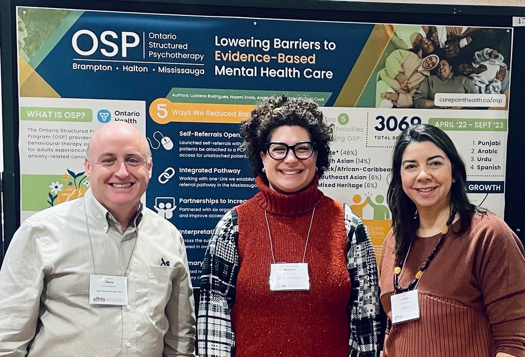 three people standing in front of a poster that says lowering barriers to evidence-based mental health care