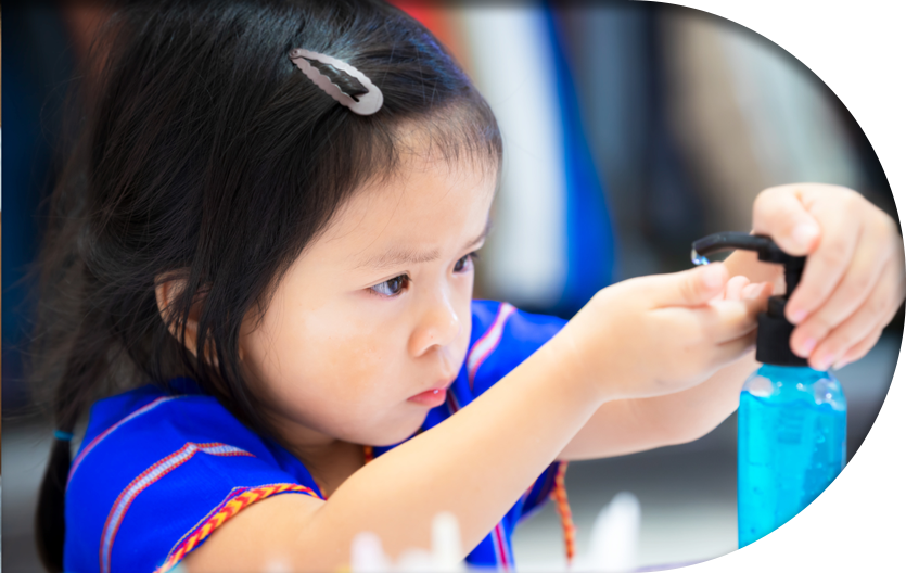 A kid in daycare using a hand sanitizer