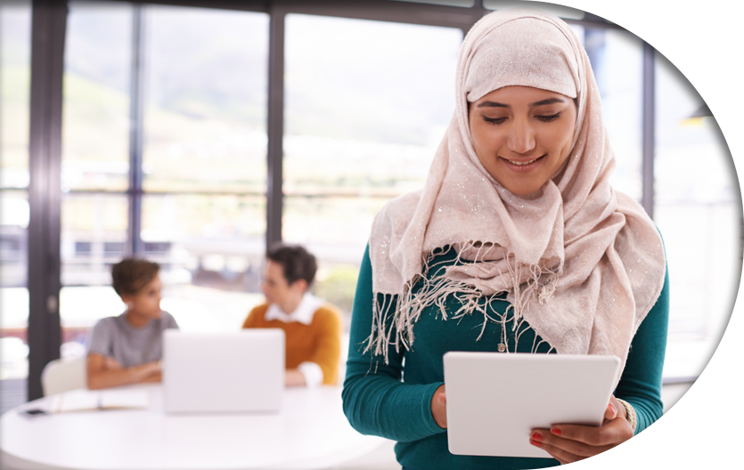 An office employee smiling in accomplishment while using her tablet