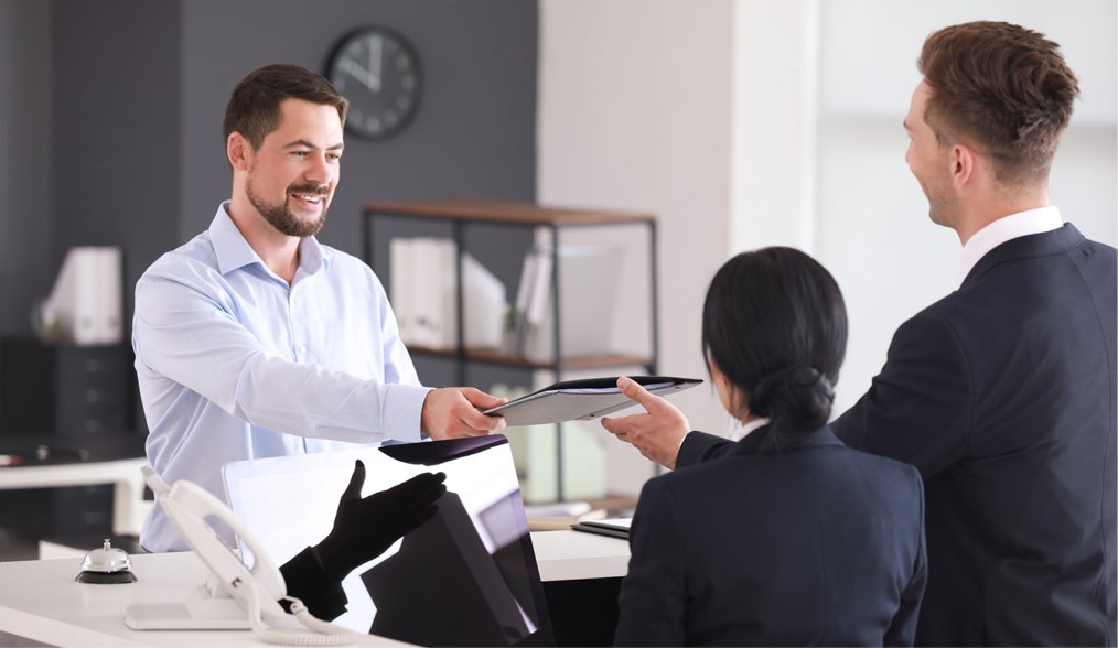 An office visitor happily greeted by employees