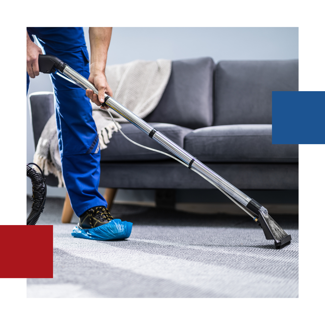 A man is using a vacuum cleaner to clean a carpet in a living room.