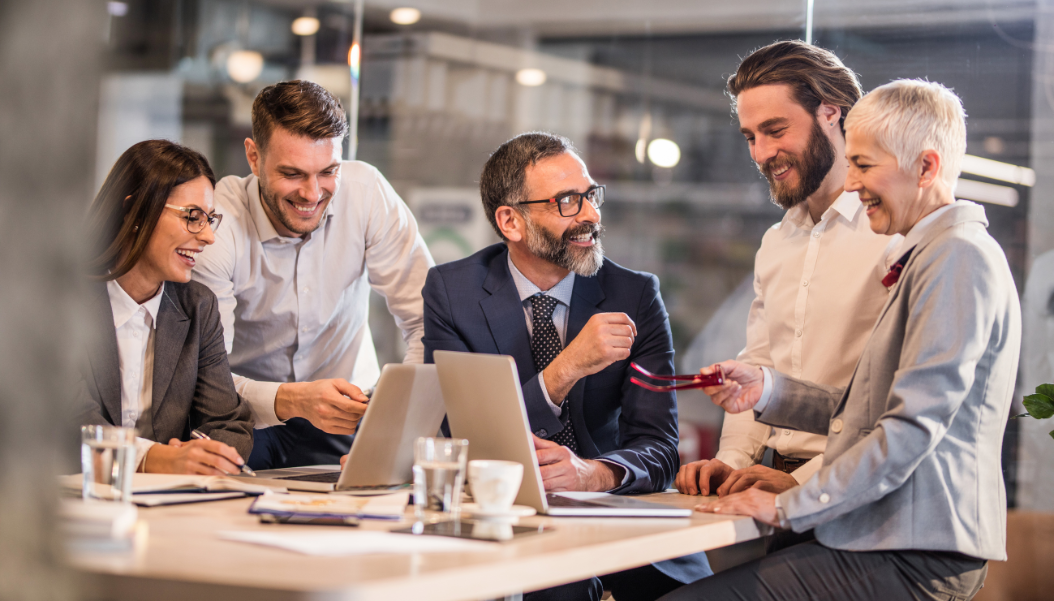 Happy business team communicating while working on computers in a clean office