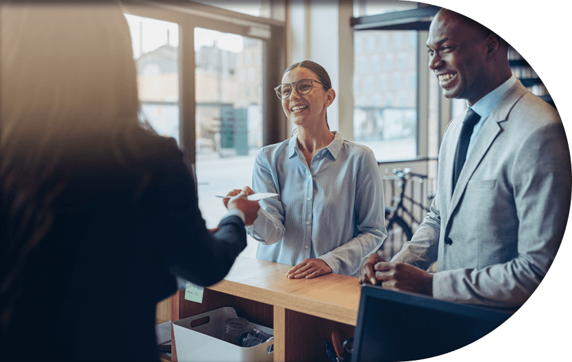 Happy office guests talking to receptionist