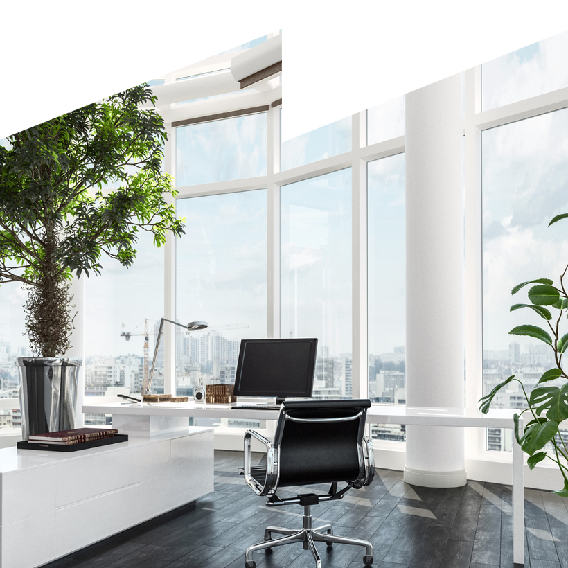 An office room with a desk , chair , computer and potted plant.