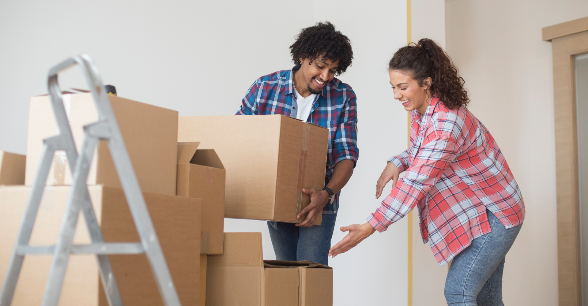 A young man and woman moving boxes into a stack