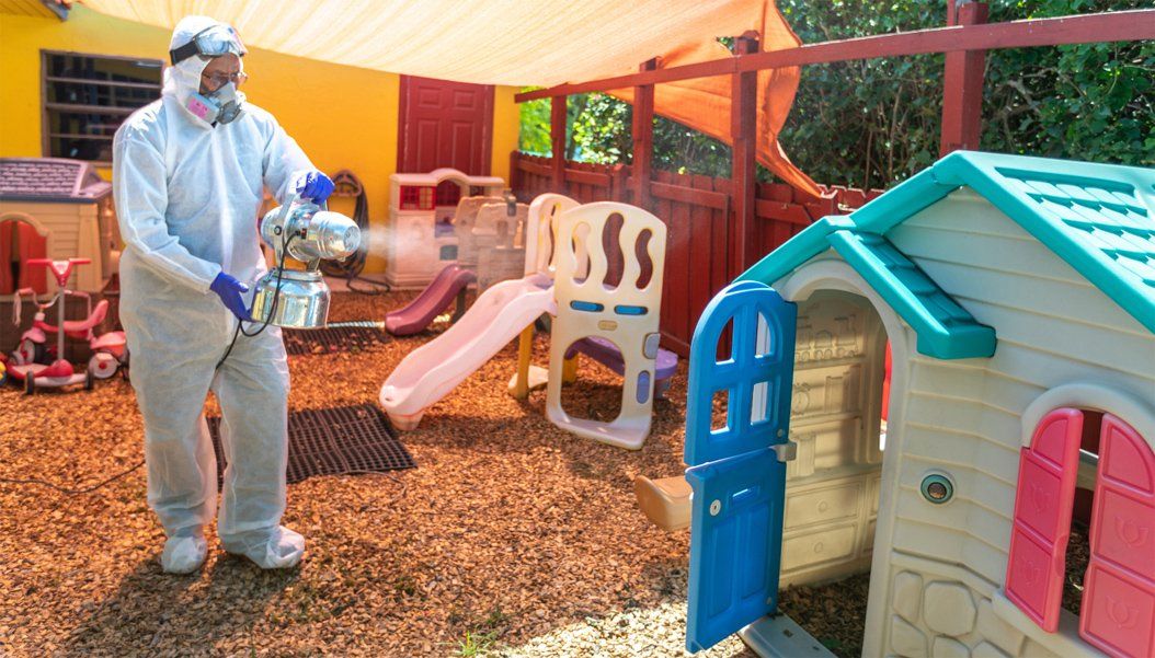 Playground being cleaned by professional in a safety suit